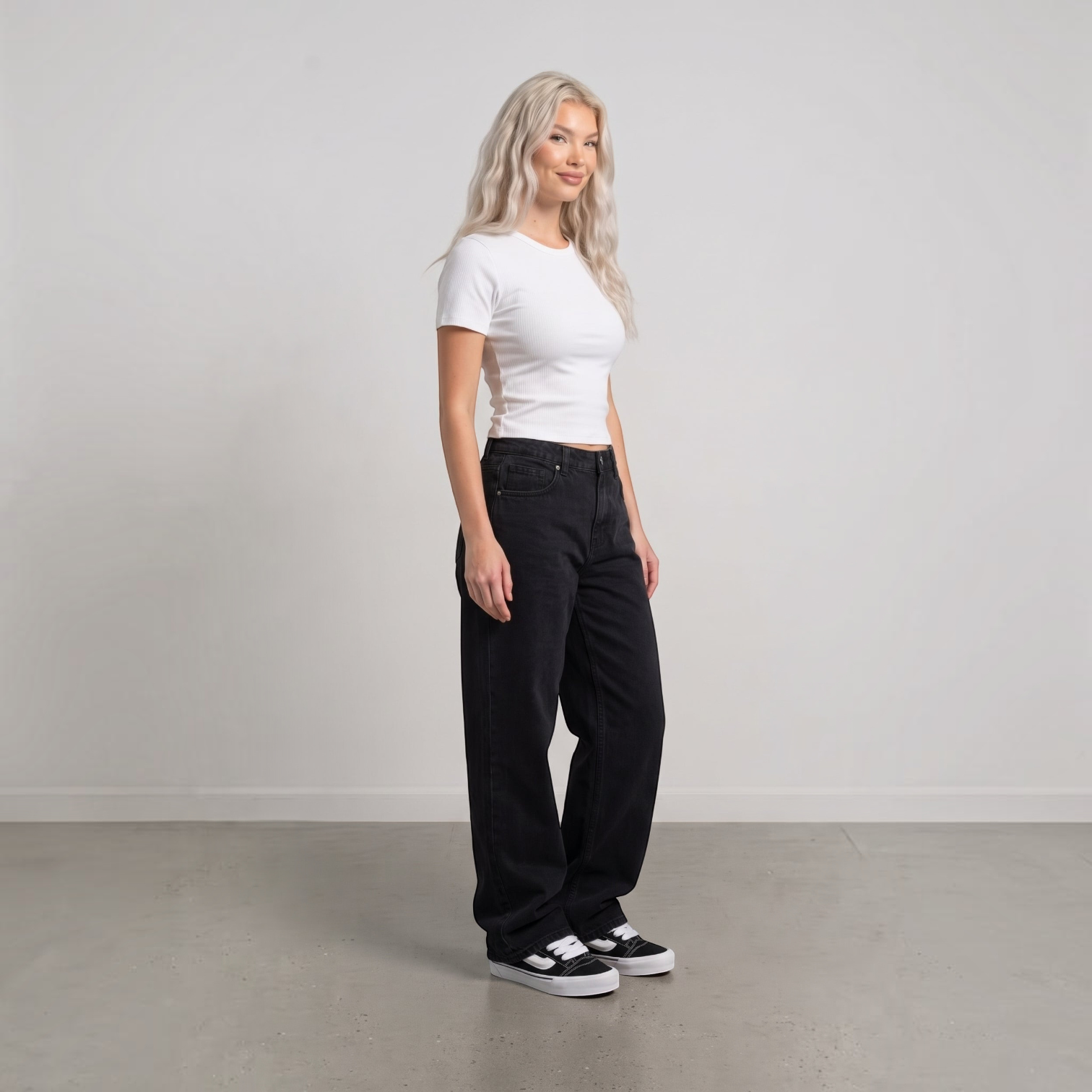 NDO Clothing Model trägt Vans KNU SKOOL Sneaker in Schwarz mit weißem Streifen zu schwarzer Jeans und weißem Shirt