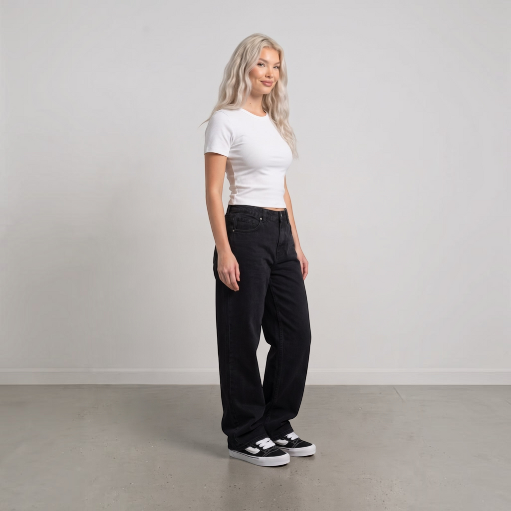NDO Clothing Model trägt Vans KNU SKOOL Sneaker in Schwarz mit weißem Streifen zu schwarzer Jeans und weißem Shirt