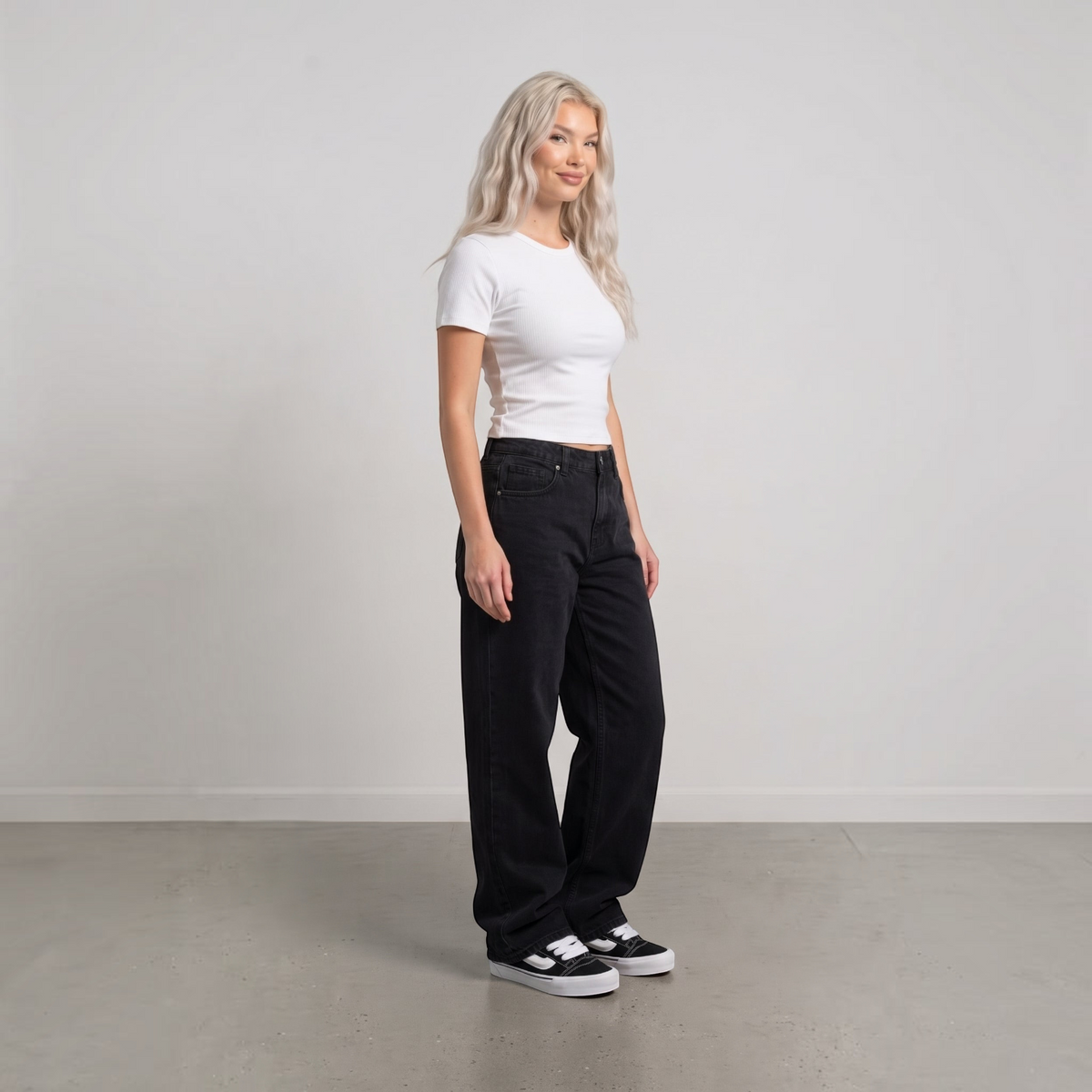 NDO Clothing Model trägt Vans KNU SKOOL Sneaker in Schwarz mit weißem Streifen zu schwarzer Jeans und weißem Shirt